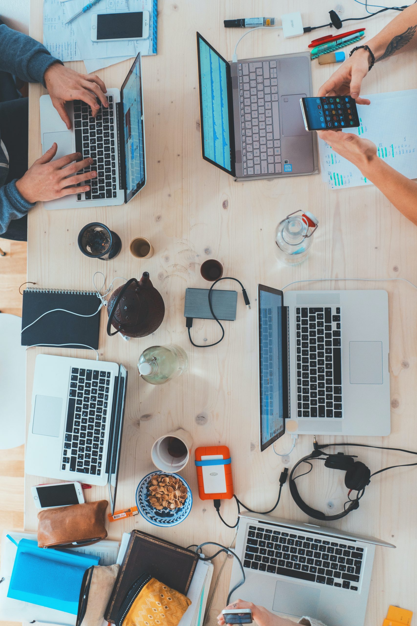 Laptops, Handys, Kopfhörern und viel weiterer Krimskrams liegen an einem Tisch